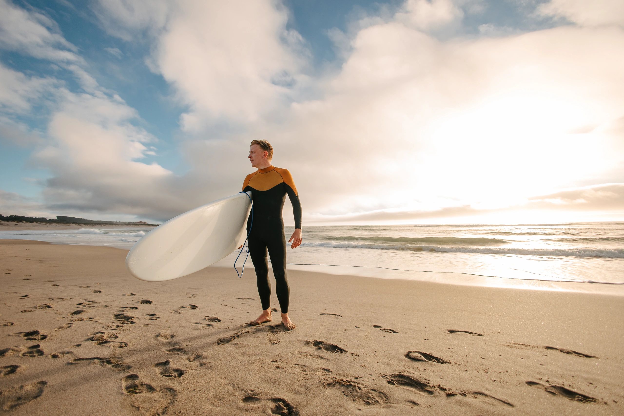 Surfer holding surfboard and posing